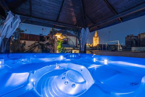 a jacuzzi tub at night with a view of the city at El Rey Moro Hotel Boutique in Seville