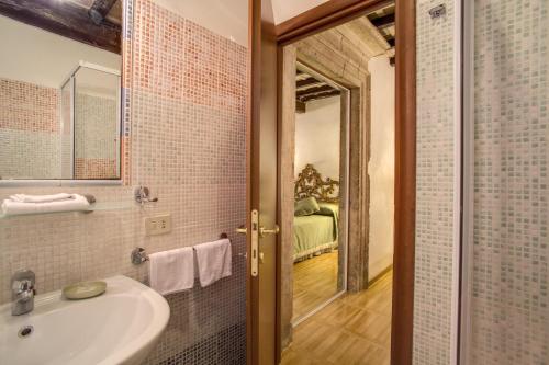 a bathroom with a tub, sink and mirror at Navona Gallery Suites in Rome
