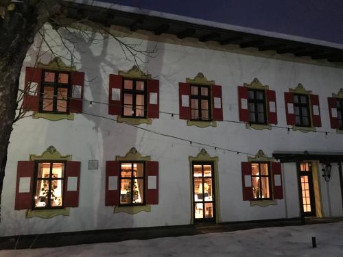 a building with red shuttered windows at night at Posthotel Sachrang in Sachrang