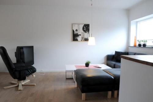 a living room with a black chair and a television at Skagen Apartment in Skagen