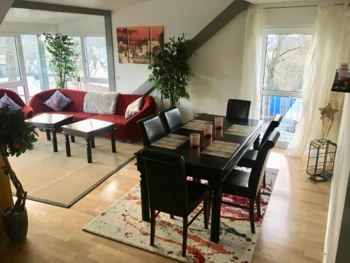 a living room with a table and a red couch at Appartment Döllinger Messe Fränkisches Seenland in Schwabach