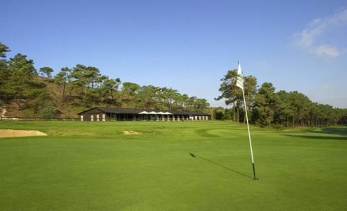 einen Golfplatz mit Putting Green mit Flagge in der Unterkunft Exciting Beach Villa in Charneca