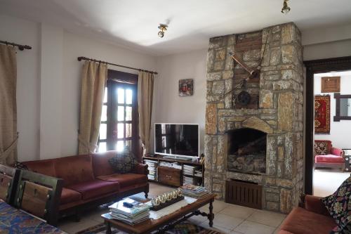 a living room with a couch and a stone fireplace at Loca Hotel in Selimiye