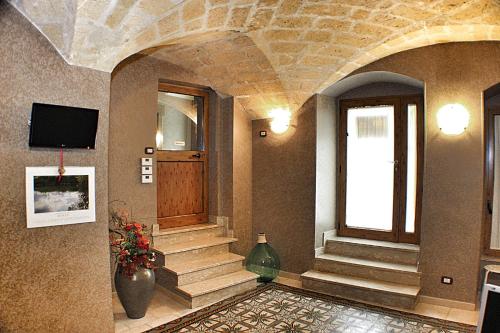 a lobby with stairs and a television in a building at B&B Duca Orsini in Gravina in Puglia
