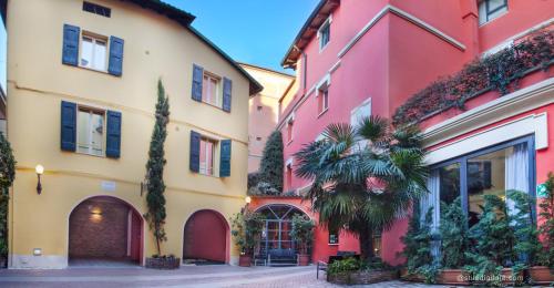 a row of colorful buildings in a street at Hotel Il Guercino in Bologna