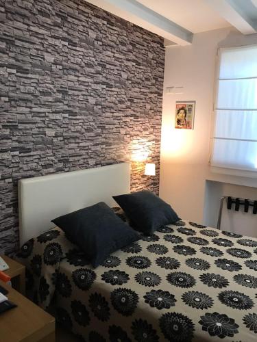 a bedroom with a bed and a brick wall at Hotel Il Guercino in Bologna