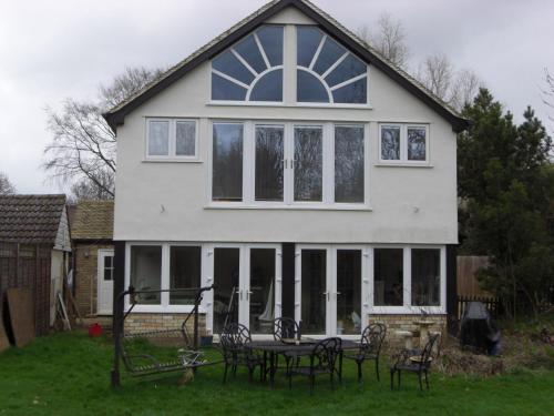 a white house with a table in front of it at The Brambles B&B in Waterbeach
