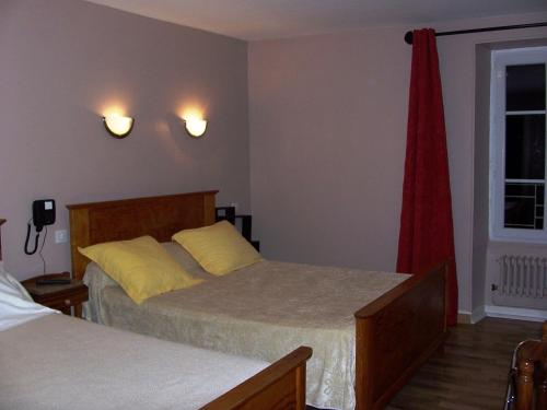 a bedroom with two beds and a window at La Vieille Auberge in Saint-Privat-dʼAllier