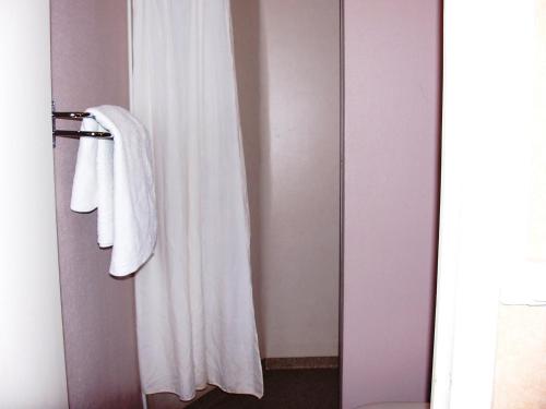 a bathroom with a white towel hanging on a door at La Vieille Auberge in Saint-Privat-dʼAllier