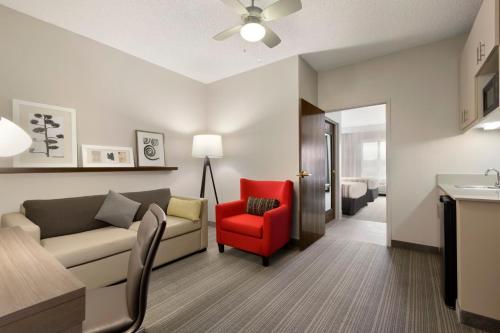 a living room with a couch and a red chair at Country Inn & Suites by Radisson, Austin North Pflugerville , TX in Round Rock