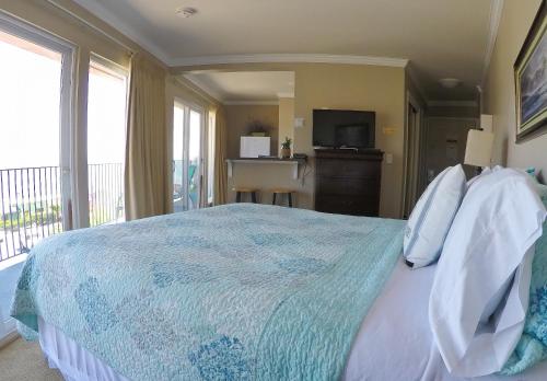 1 dormitorio con 1 cama, TV y balcón en Capitola Beach Suites, en Capitola