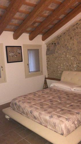 a bedroom with a bed and a stone wall at B&B Agli Angeli in Pieve di Soligo