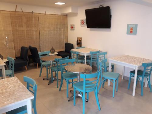 a dining room with tables and chairs and a flat screen tv at Playa Hotel - Cavancha in Iquique