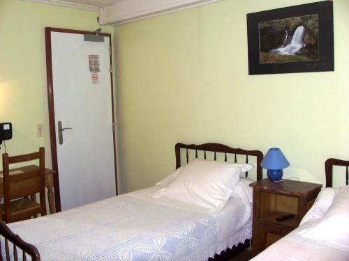 a bedroom with two beds and a door with a picture at La Vieille Auberge in Saint-Privat-dʼAllier