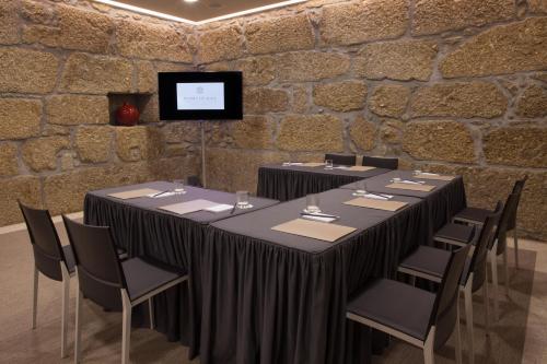 a room with a table and chairs and a tv at Madre de Água Hotel Rural de Charme in Gouveia