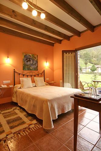 a bedroom with a bed and a large window at La Ablaneda in Soto de Cangas