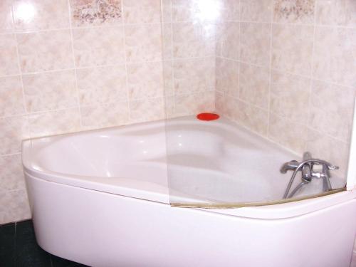 a white bath tub in a tiled bathroom at La Vieille Auberge in Saint-Privat-dʼAllier