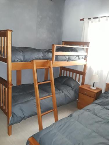 1 dormitorio con 2 literas y 1 cama en La Casita De Lunlunta en Luján de Cuyo