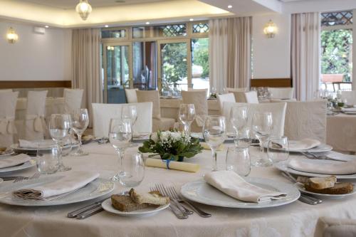 a white table with plates and wine glasses on it at Montespina Park Hotel in Naples