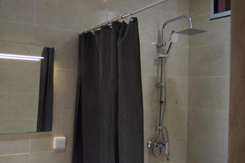 a shower with a black shower curtain in a bathroom at Résidence Blue hôtel in Thiès