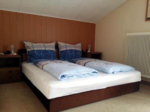 een slaapkamer met een bed met blauwe en witte kussens bij Apartmenthaus Erna in Bad Hofgastein