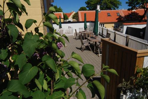 a balcony with tables and chairs and a fence at Skagen Room in Skagen