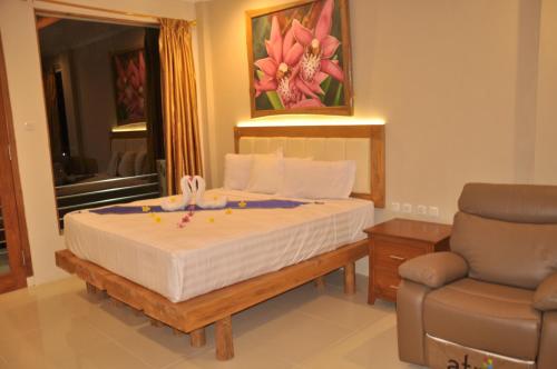 a bedroom with a bed with a chair and a window at Crystal Beach Bali in Candidasa
