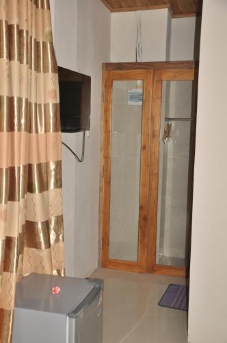 a room with a television and a door with a curtain at Crystal Beach Bali in Candidasa