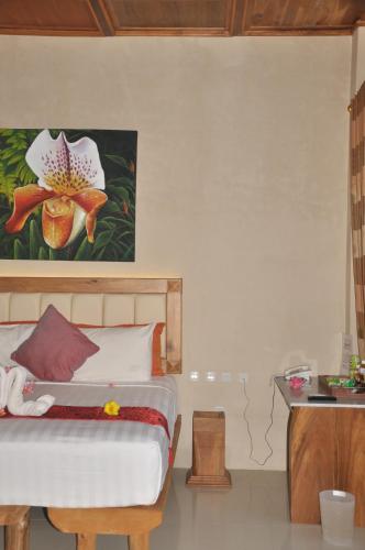 a bedroom with a bed and a painting on the wall at Crystal Beach Bali in Candidasa