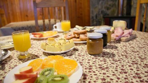a table topped with plates of food and orange juice at Hotel Último Paraíso in Cochrane