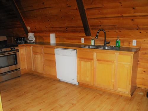 a kitchen with wooden cabinets and wooden floors at Eagle Crater Lake Inn in Chemult