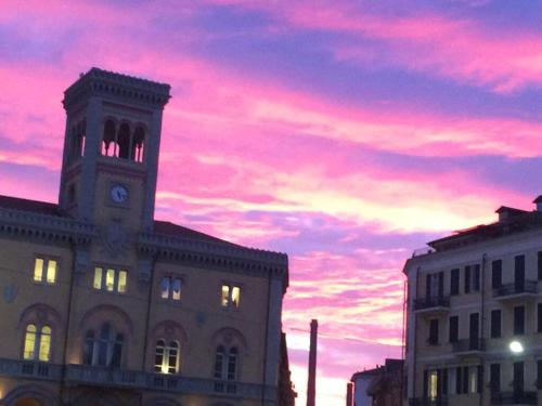 a building with a clock tower with a sunset at B&b note di mare in Imperia