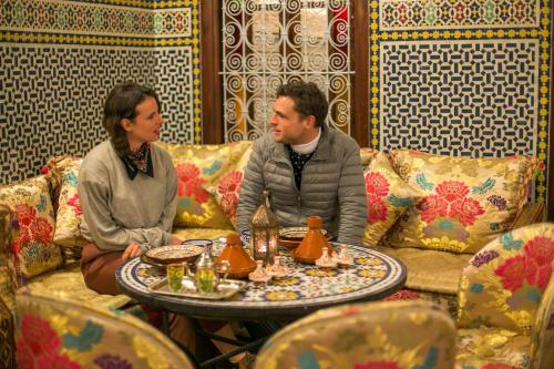 a man and a woman sitting at a table at Dar Fes Tresor in Fès