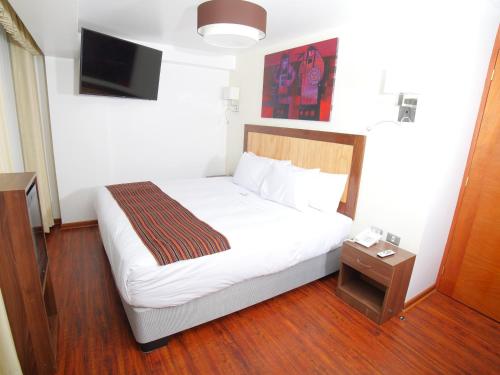 a hotel room with a bed and a tv at Golden Sunrise Machupicchu in Machu Picchu