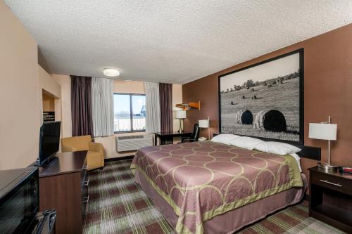 a hotel room with a bed and a flat screen tv at Super 8 by Wyndham Campbellsville KY in Campbellsville