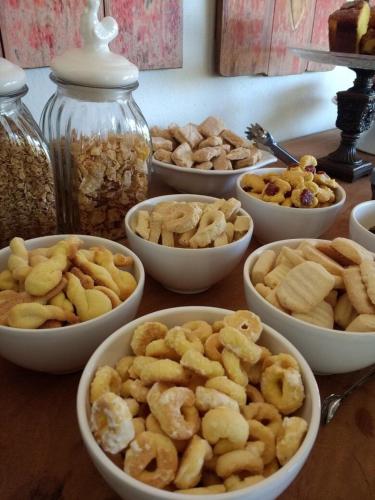 een tafel vol schalen met noten en andere snacks bij Pousada Divina Minas in Três Corações