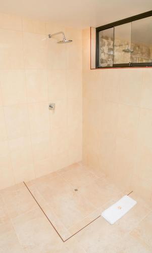 a bathroom with a shower with a tile floor at Golden Sunrise Machupicchu in Machu Picchu