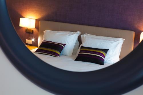 a reflection of a bed with pillows in a mirror at Madre de Água Hotel Rural de Charme in Gouveia