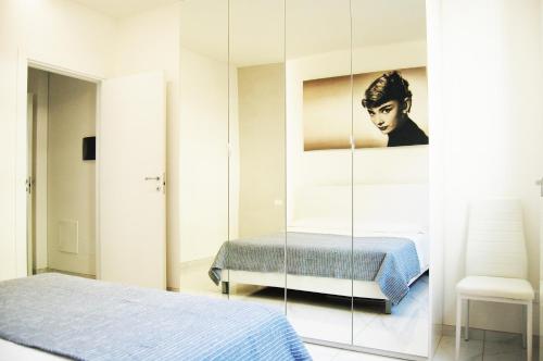 een slaapkamer met een bed en een spiegel bij Maison Audrey in Desenzano del Garda