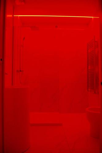 a red room with a toilet and a sink at Maison Audrey in Desenzano del Garda