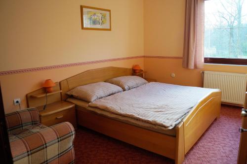 una camera con un letto e una sedia di Békesség Szigete, Klasszik Apartman a Súr
