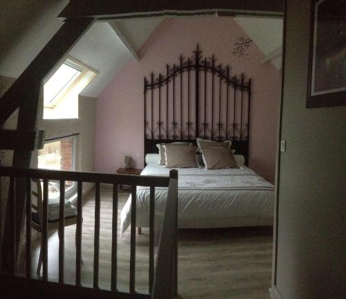 a bedroom with a large bed with a wrought iron headboard at La Reine des Prés in Marly-Gomont