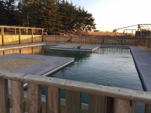 a pool of water next to a wooden fence at Hecmar 2 in Pichilemu