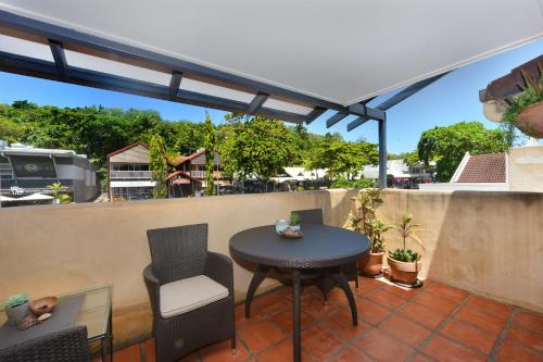 a patio with a table and chairs on a balcony at Seascape Apartments at Villa San Michele in Port Douglas