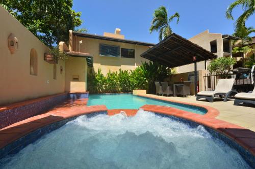 a swimming pool with a water feature in a yard at Seascape Apartments at Villa San Michele in Port Douglas