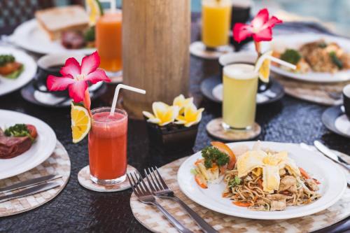 a table topped with plates of food and drinks at Villa Gusmania in Candidasa