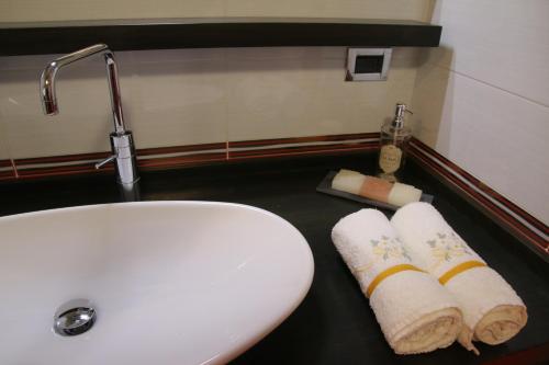 サンレモにあるGaudio 22 Apartmentのバスルーム(シンク、カウンターのタオル2枚付)