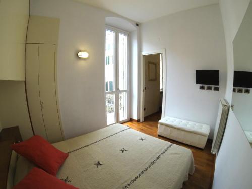 a white room with a bed and a window at Gaudio 22 Apartment in Sanremo
