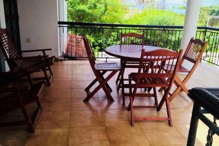 a porch with a table and chairs on a balcony at Ran-Weera Villa in Kahawa