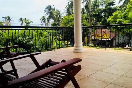 a wooden bench sitting on top of a balcony at Ran-Weera Villa in Kahawa